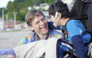 Father enjoying beach with disabled son