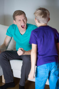 Young furious father yelling at his little son