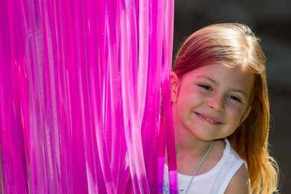 Girl smiling next to luminous pink lighting tubes