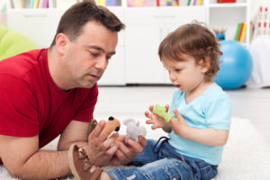 Father and toddler son playing