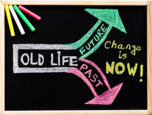 Change is now, handwriting with chalk on wooden frame blackboard, colored chalk in the corner, lifestyle change concept