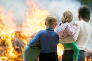 Family mother with children at burning house background