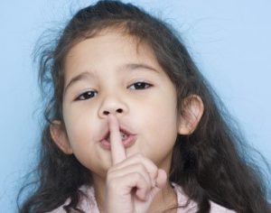 Portrait of girl with finger over mouth