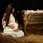 the-nativity-through-an-adoption-lens-part-2.Pregnant Mary holding stomach at manger on Christmas Eve
