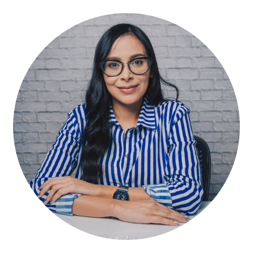 Woman in glasses and striped shirt smiling at the camera.